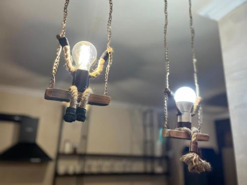 dos luces colgando de cadenas en una habitación en Милый Дом en Vanadzor