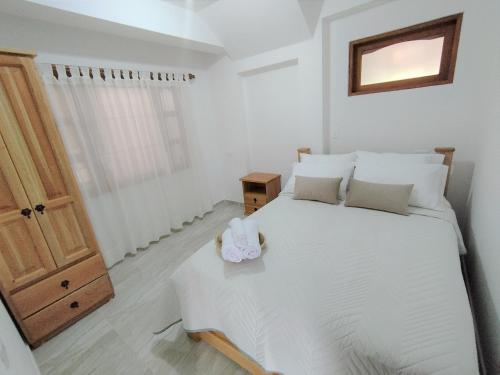 萊瓦鎮的住宿－Apartamento en Villa de Leyva，卧室配有白色的床和木门