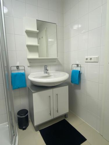 ein weißes Badezimmer mit einem Waschbecken und einem Spiegel in der Unterkunft Ferienwohnung Seeblick in Allersberg