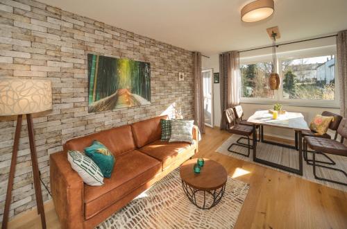 a living room with a couch and a brick wall at Berg Apartments in Oberreichenbach