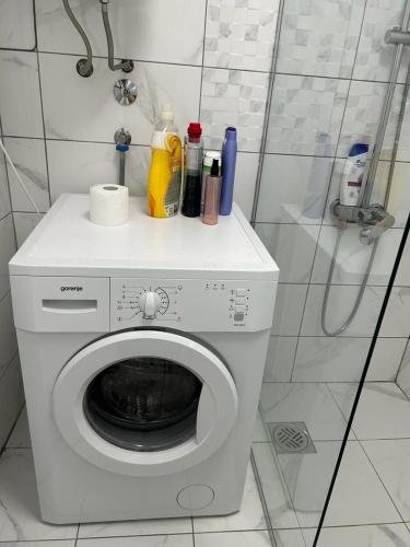 a washing machine with bottles on top of it in a bathroom at Kršić Apartman in Baošići
