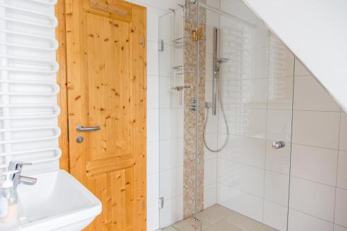 a bathroom with a shower with a wooden door at Ferienhaus Zinnwald in Kurort Altenberg