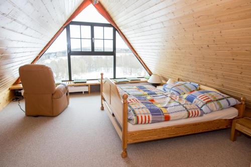 1 dormitorio con 1 cama y 1 silla en una habitación en Ferienhaus Zinnwald en Kurort Altenberg