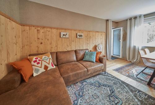 a living room with a brown couch and a rug at Berg Apartments in Oberreichenbach