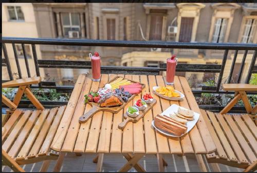 NEW CITY VIEW في القاهرة: طاولة خشبية مع طعام فوق الشرفة