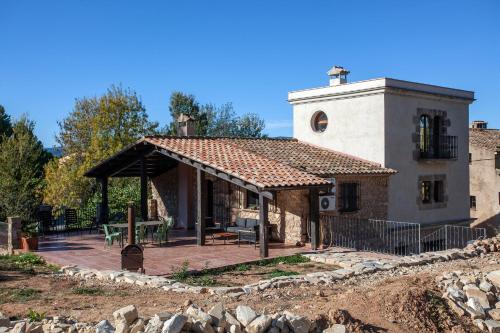 a large stone building with a porch and a tower at Casa Maro Prenafeta in Prenafeta