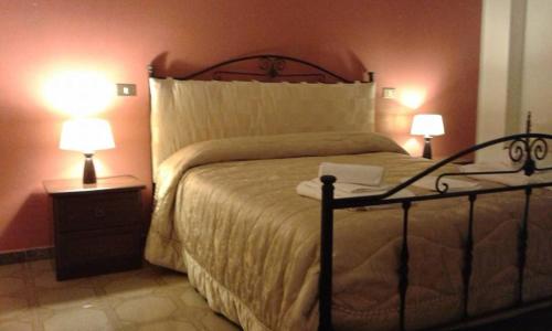 a bedroom with a large bed with two lamps at Casa Rosanna in Terrasini