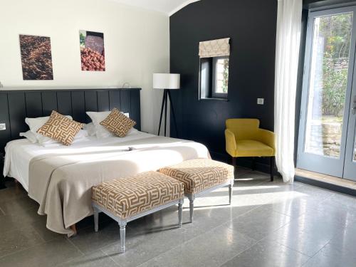 una camera con un grande letto e una sedia gialla di Domaine de l'Enclos a Gordes