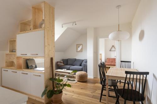 eine Küche und ein Wohnzimmer mit einem Tisch und Stühlen in der Unterkunft Apartment ZEN High Tatras in Veľká Lomnica