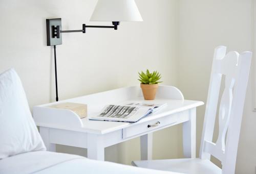 a white desk with a plant on it next to a bed at Laguna Beach House in Laguna Beach