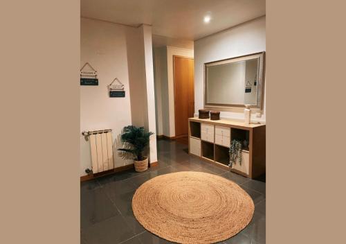 a large living room with a round rug and a television at Apartamento Familiar T3 em Valongo com Terraço Privativo e Churrasqueira in Campo