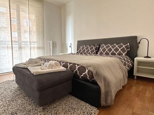 1 dormitorio con 1 cama grande con reposapiés al lado en Casa Spezia - Metro Vicina, Wi-Fi Rapido & Netflix en Turín