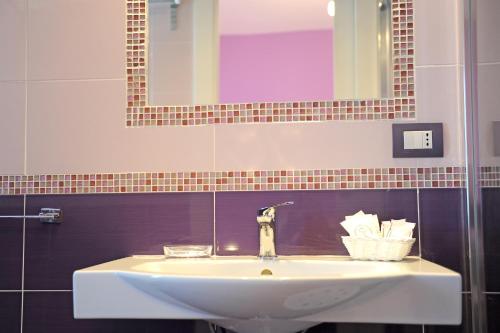a white sink in a bathroom with a mirror at L'Isola Del Postino Rooms in Procida