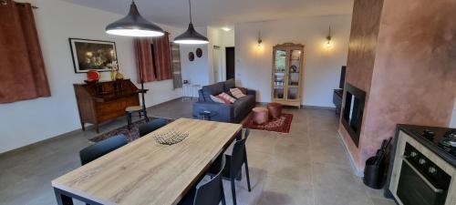Oltre la Siepe Apartment في Nepi: غرفة معيشة مع طاولة خشبية وأريكة