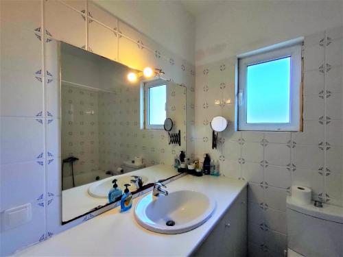 a bathroom with a sink and a mirror at Batsi Bay View Maisonette in Andros