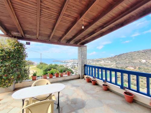 a patio with a table and chairs on a balcony at Batsi Bay View Maisonette in Andros