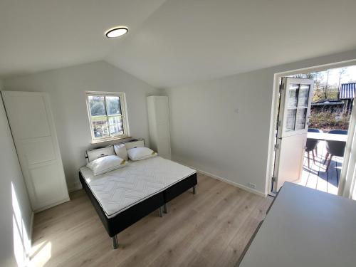 a bedroom with a bed and a large window at Sommerhus ved Mossø med søkig in Skanderborg