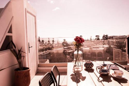 una mesa con un jarrón de flores en el balcón en Dar YAMAR en Esauira