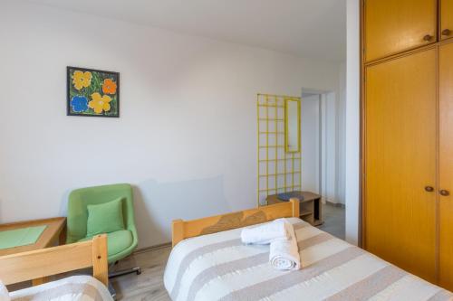 ein Schlafzimmer mit einem Bett und einem grünen Stuhl in der Unterkunft App Sophia in Pula