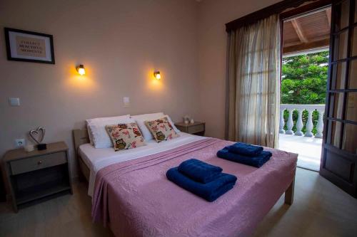 Un dormitorio con una cama con dos almohadas azules encima. en Georgia Apartment Acharavi Corfu, en Acharavi