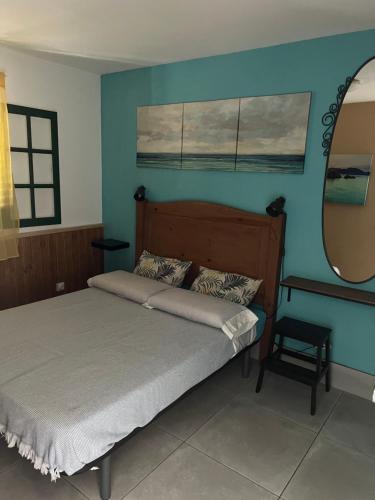 ein Schlafzimmer mit einem Bett und einer blauen Wand in der Unterkunft Apartamento Los Lagos in Cotillo