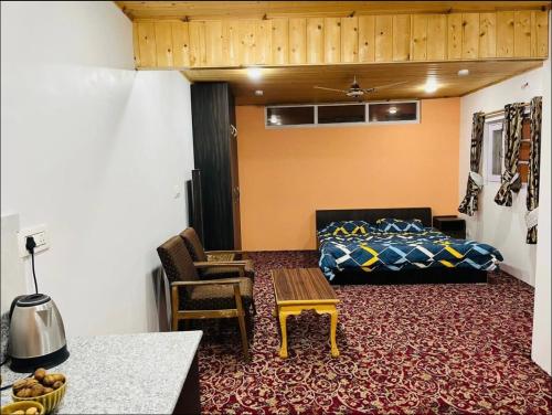 a bedroom with a bed and a table and a chair at Ashai Villa Studio Apartment in Srinagar in Srinagar
