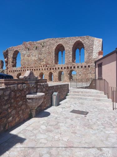a brick building with three windows and a stone wall at Al Castello in San Marco dʼAlunzio