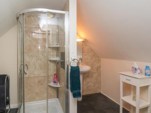 a bathroom with a shower and a sink at Cow Byre Cottage in Whitby
