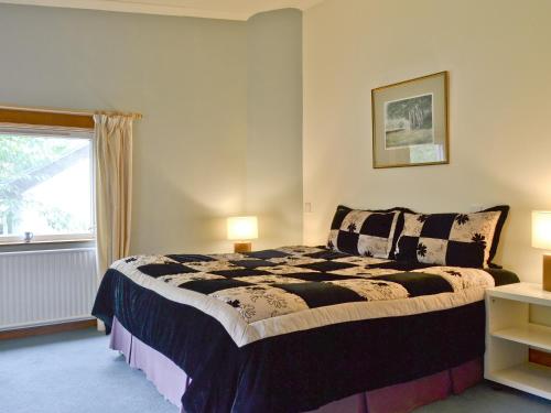 a bedroom with a large bed and a window at Sgurr Mor Lodge - Smmd in Balmacara