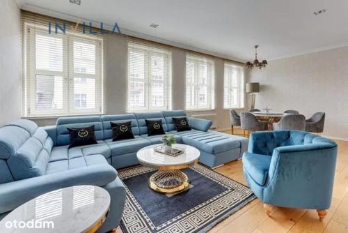 a living room with a blue couch and chairs at Apartament Faltom Gdynia Centrum in Gdynia