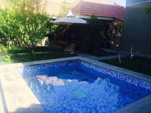 a swimming pool with blue water in a yard at Argavand Hotel & Restaurant Complex in Argavand