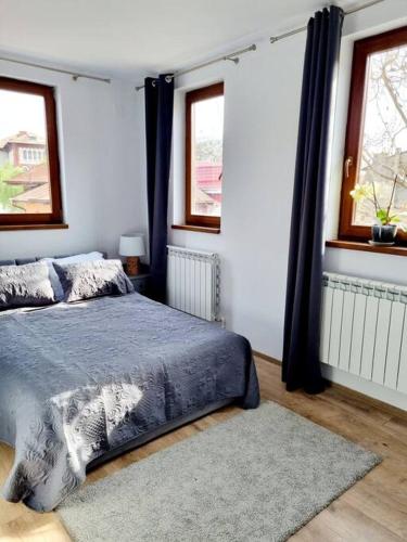 um quarto com uma cama, 2 janelas e um tapete em Cozy apartment near city center em Bucareste