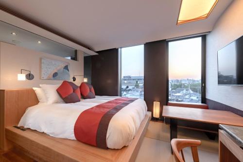 a bedroom with a large bed and a desk at Genji Kyoto, a Member of Design Hotels in Kyoto