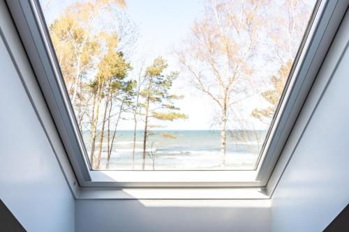 a window in a room with a view of the ocean at Villa & Domek Maja in Sarbinowo