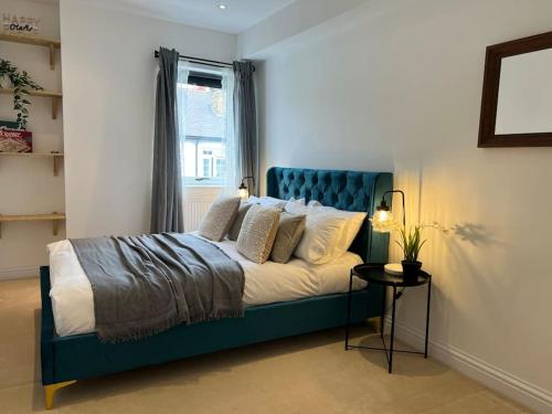 a bed with a blue headboard in a bedroom at East Rd in London