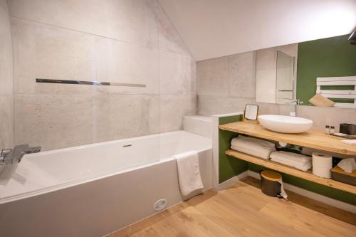 La salle de bains est pourvue d'une baignoire et d'un lavabo. dans l'établissement Hôtel Restaurant Le Fiacre à Quend plage, à Quend