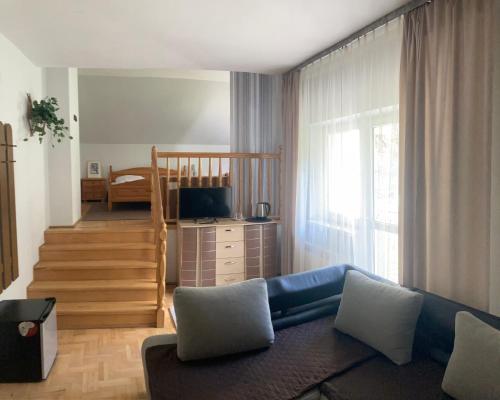 ein Wohnzimmer mit einem Sofa und einem Bett in der Unterkunft Amphora Kompleks Wypoczynkowy in Krynica-Zdrój