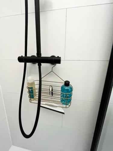 a shower head with a hose hanging on a wall at The East Wing Bloemendaal in Bloemendaal