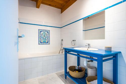 bagno con lavandino blu e vasca di La Bastide des Joncquiers a LʼIsle-sur-la-Sorgue
