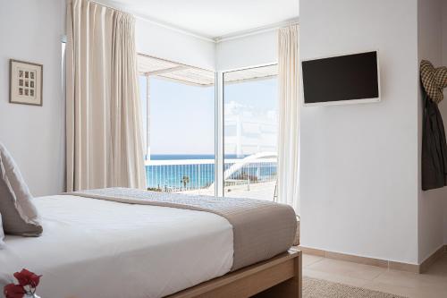um quarto com uma cama e uma grande janela em Sea View Beach Penthouse - Athens Coast em Atenas