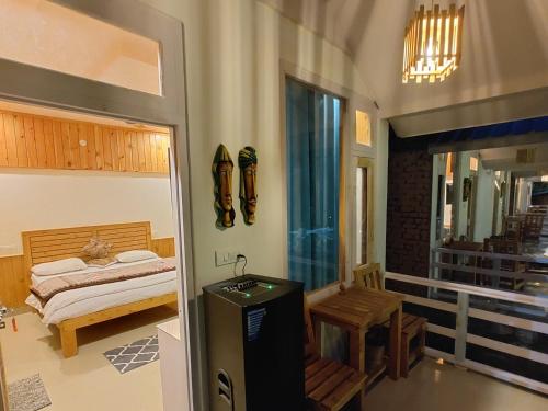 a bedroom with a bed and a table and a window at The Stream Kasol in Kasol