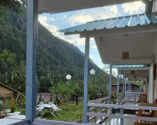 a view from the porch of a house with a mountain at The Stream Kasol in Kasol