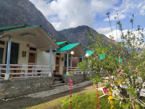 a house with a mountain in the background at The Stream Kasol in Kasol