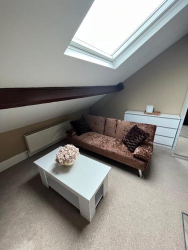 a living room with a couch and a table at Modern En-Suite Rooms Town Centre Self-Check In in Barnsley