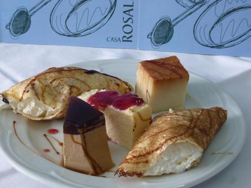 a white plate with different types of cheeses and pies at Hotel Gastronómico Casa Rosalia in Brion