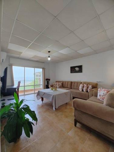 sala de estar con sofá y mesa en Large Vacation Apartment With A Stunning View In Isfiya, Mount Carmel - דירת נופש עם נוף מדהים בעספיא, en ‘Isfiyā