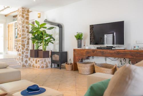 un soggiorno con TV e divano di Villa Horizonte - Eivillas Ibiza a Port des Torrent