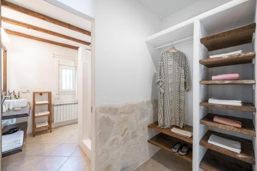 een kleedkamer met witte muren en houten planken bij Villa Horizonte in Port des Torrent