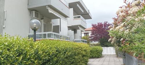 un bâtiment blanc avec un lampadaire devant dans l'établissement La casina di Ale, à Marina di Carrara