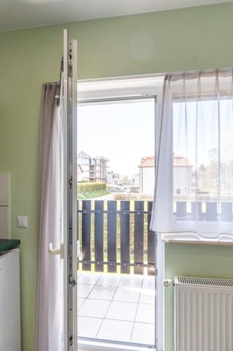 a sliding glass door with a view of a balcony at Villa & Domek Maja in Sarbinowo